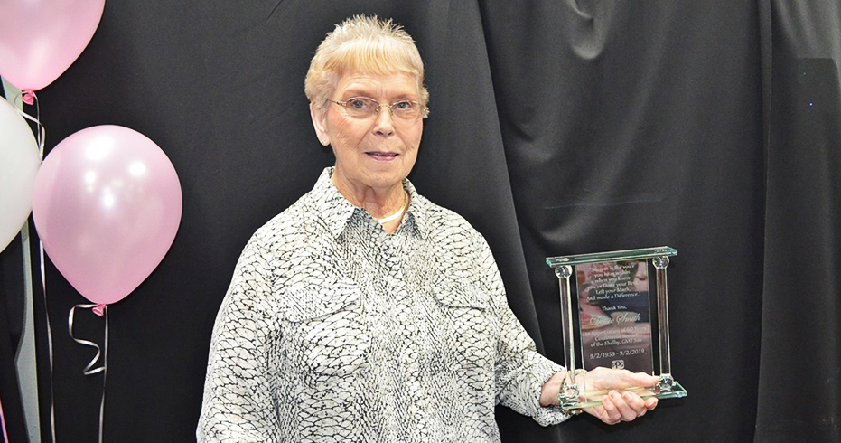 黛西·史密斯（Dessie Smith）女士亮出纪念她在韩华高新材料谢尔比工厂工作60周年的纪念牌。纪念牌上印刻着60年间经营过该工厂的三个公司的LOGO