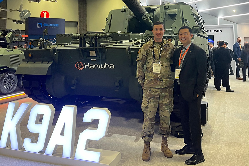 Jason Pak with a U.S. Army officer in front of Hanwha's artillery vehicle at a defense industry event.