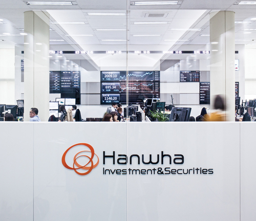 Hanwha Investment & Securities employees review the latest data prior to a client meeting.