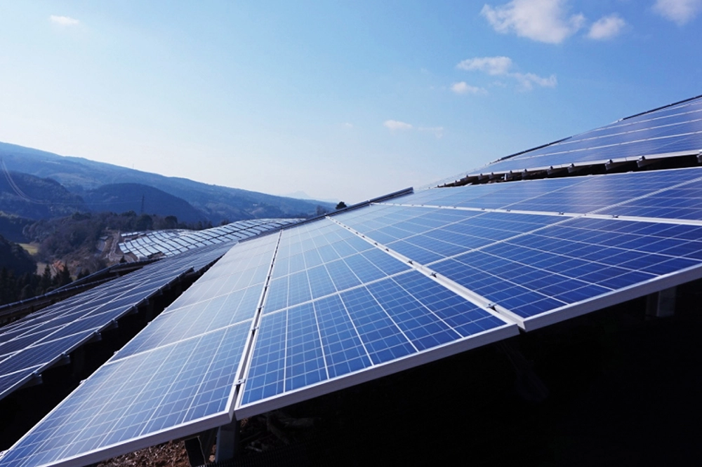 Solar panels installed on a hillside under a clear blue sky, capturing solar energy for sustainable power.