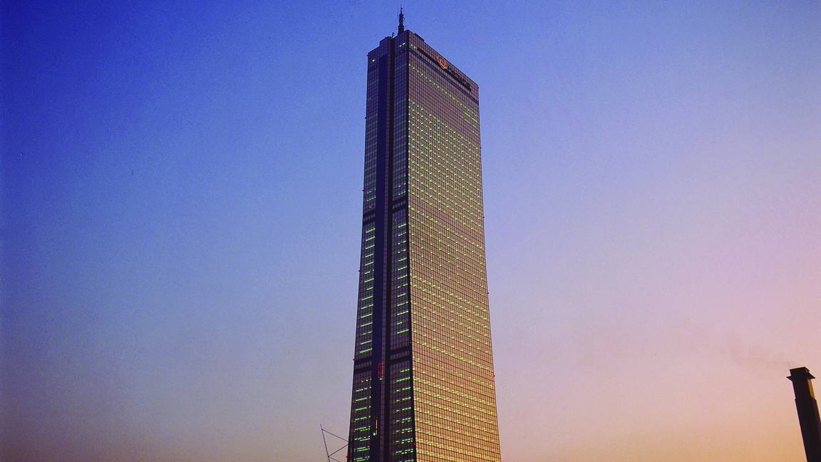 The tall, golden-colored 63 Building in Seoul, Korea, seen from a distance in twilight