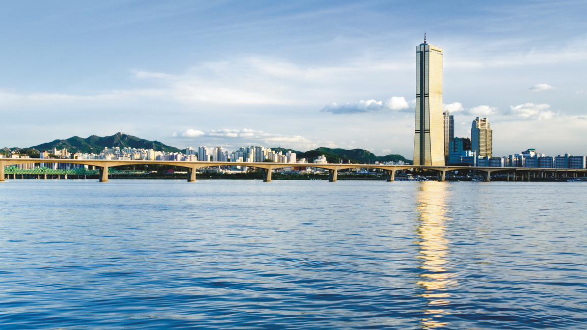 The tall, golden-colored 63 Building in Seoul, Korea, seen from across the Han River on a sunny day