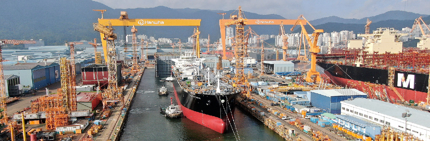 A shipyard with an LPG vessel equipped with a dual fuel engine, surrounded by cranes and industrial equipment 